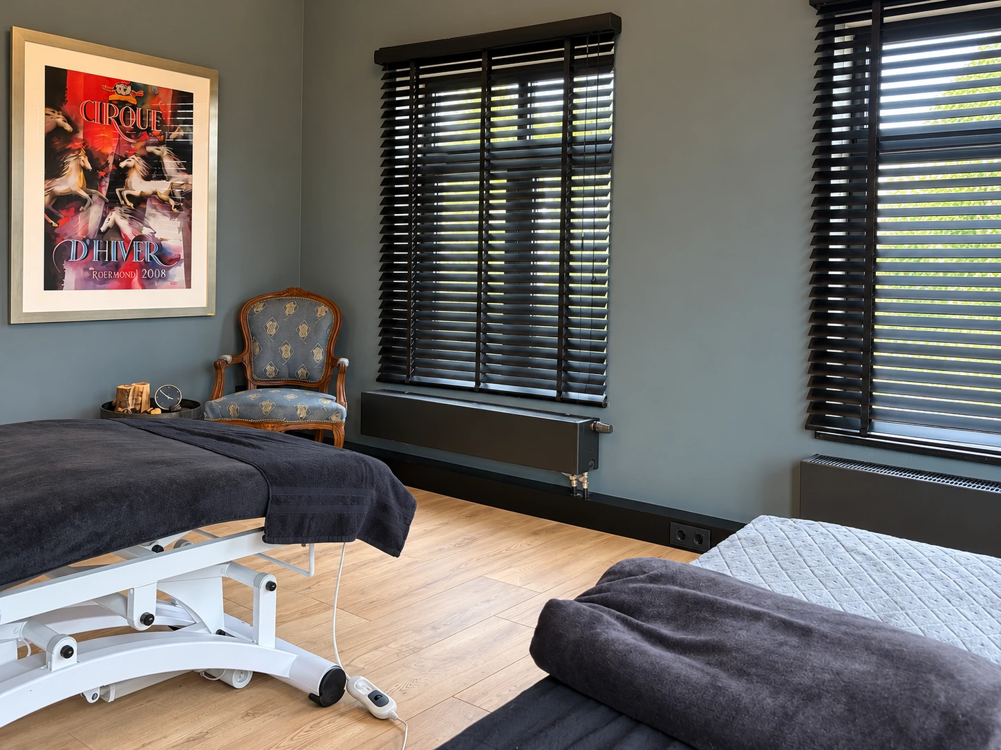 De behandelruimte van Atalanta Wellness met twee behandelbanken, hoge ramen en warme materialen