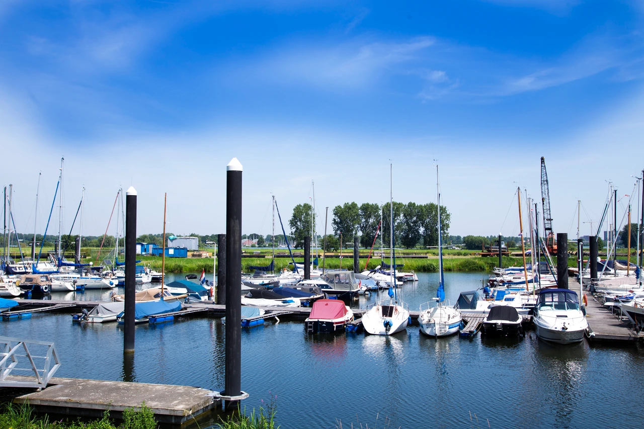 Zeilboten en steigers in een jachthaven bij Roermond